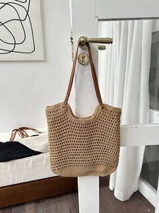 Detailed view of handmade woven tote bag featuring hollow knit design and brown leather straps