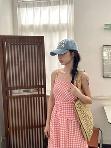 Détail d'une casquette en jean bleu clair ornée de petits nœuds blancs sur le côté