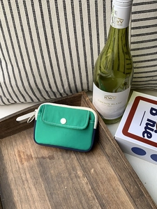 Mini canvas coin purse in green and navy blue color block with white zipper and snap pocket