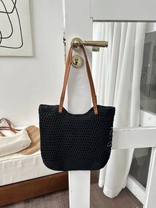 Detail of handwoven black honeycomb mesh tote with brown faux leather shoulder strap