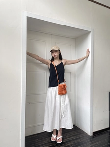 Detail of orange hand-knitted mini crossbody bag with hollow weave and cotton texture