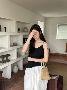 Close-up of lightweight woven straw basket bag styled with minimalist summer outfit