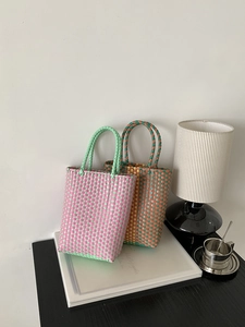 Detail shot of colorful hand-woven PVC beach bags showing intricate mesh texture