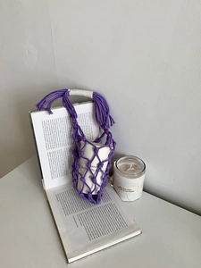 Vue détaillée du porte-bouteille violet tissé à la main avec motif filet sur livre