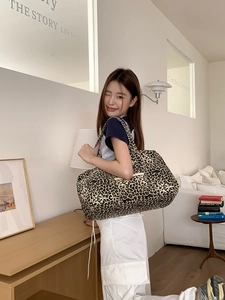 Detail of leopard print canvas tote bag featuring a front zipper pocket and large capacity