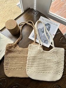 Close-up of handmade hollow crochet cotton bags in beige and off-white on vintage wood