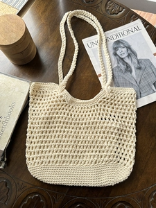 Detail of hollow crochet texture on ivory cotton woven tote bag with braided handles