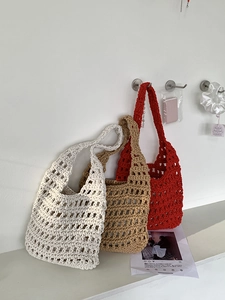 Detail of three handmade woven cotton rope bags in ivory, khaki, and vibrant red