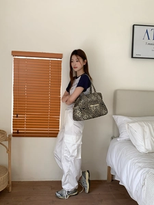 Detailed view of leopard print tote bag styled with casual outfit in a home setting