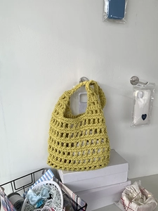 Detail of the intricate yellow cotton rope hollow mesh texture of a handwoven tote bag