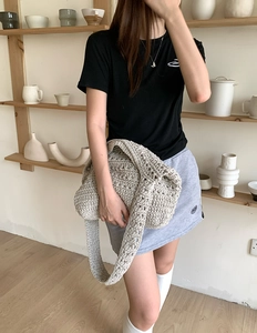 Detail of hand-woven cotton texture and sturdy shoulder strap on beige crochet tote