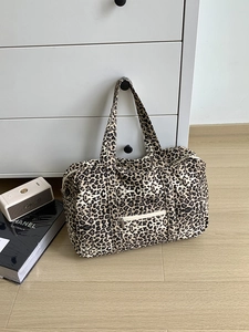 Macro shot of large leopard print canvas tote bag with front zipper pocket and dual handles