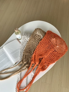 Detail of three-color handmade woven cotton mesh bags with reinforced braided handles