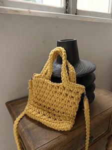 Detail of yellow hand-woven cotton shoulder bag featuring metallic silver hardware