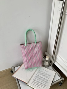 Detail of pink and mint green PVC handwoven basket bag with textured mesh pattern