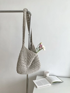 Detail of hand-woven cotton tote bag featuring a beige hollow crochet honeycomb texture