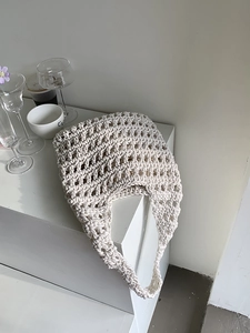 Detail of hand-woven cream cotton rope shoulder bag with mesh hollow texture design