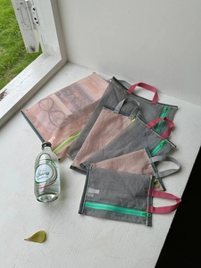 Detailed macro view of semi-transparent mesh storage bags with vibrant green zippers