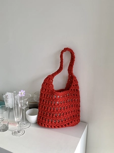 Detail of red crochet tote bag showing hollow mesh pattern and woven cotton rope texture