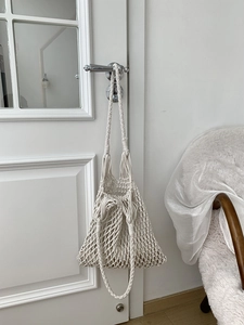 Detail of white handmade cotton rope weave and mesh texture on hollow shoulder bag