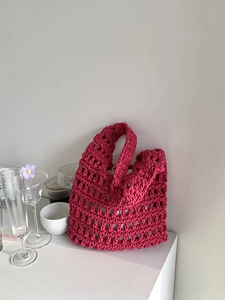 Detail of a handmade pink crochet tote bag featuring a hollow knit cotton rope texture