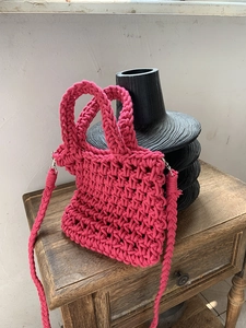 Detail of hand-woven hot pink cotton rope mini bag showing intricate hollow texture