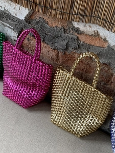 Chic woven beach basket tote with metallic finish in vibrant magenta and gold tones