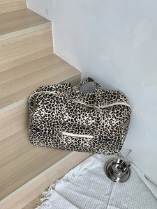 Macro shot of large leopard print canvas tote bag with front zipper pocket and handles