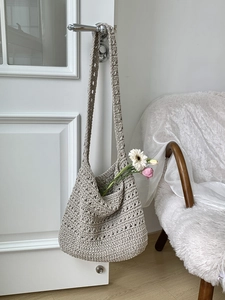 Detailed macro view of the handmade woven cotton rope shoulder bag with hollow crochet texture