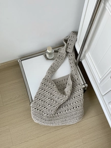 Detail of beige hand-woven cotton crochet tote bag with bohemian hollow wave pattern