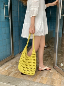 Handmade yellow crochet tote bag for summer beach holiday styled with a white dress