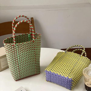 Close-up of handmade woven PVC basket bags in contrasting red-green and yellow-purple colors
