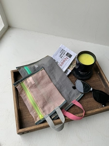 Detailed view of two-piece mesh storage bags on a wooden tray for travel organization