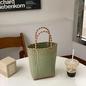 Detail of red and green plaid woven PVC tote bag placed in a lifestyle setting