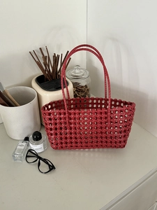 Dettaglio della borsa rossa intrecciata con doppi manici per le vacanze al mare e spiaggia