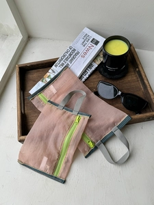 Two-piece mesh travel storage bags with pink netting and vibrant green zippers