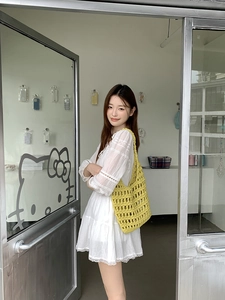 Detail of yellow hand-knitted cotton rope shoulder bag with hollow mesh design