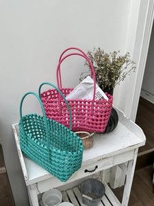 Dettaglio di cesti da picnic intrecciati a mano in rosa vibrante e verde acqua