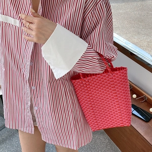 Detail of pink hand-woven PVC tote bag showing fine texture and durable summer basket handle