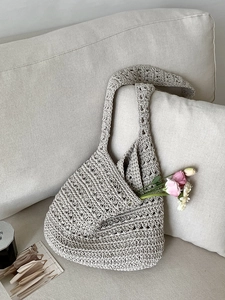 Handcrafted cream cotton woven tote bag with hollow knit design and floral display