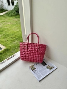 Dettaglio della borsa a cesto intrecciata rosa con motivo a rete per vacanze al mare