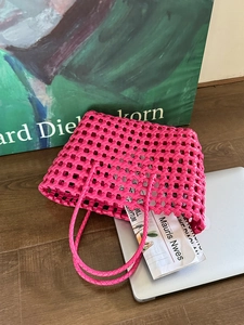 Dettaglio della borsa tote intrecciata rosa acceso con doppi manici per le vacanze