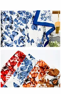 Detail of butterfly print polyester scarf showing stitching quality and various colors