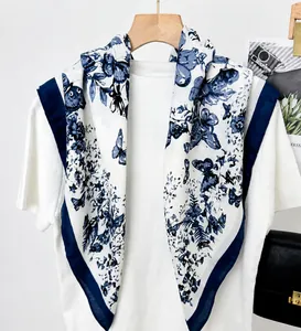 Detail of a vintage butterfly print silk-like square scarf with elegant navy blue borders