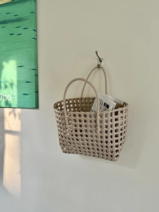Dettaglio della borsa intrecciata a mano beige per l'organizzazione della parete di casa