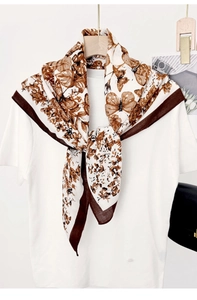 Detailed pattern of vintage butterfly and floral prints on a beige silk square scarf