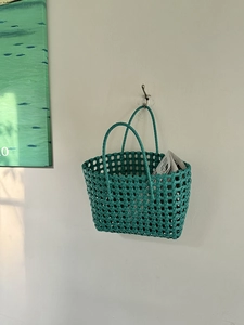 Dettaglio borsa tote intrecciata turchese con trama a rombi e manici spessi
