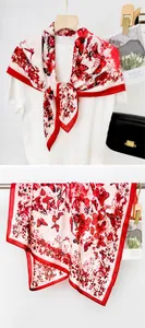Detail of a white square scarf featuring vibrant red butterfly and floral prints