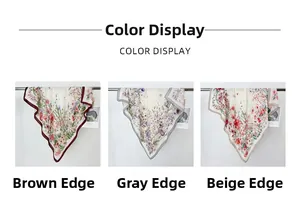 Detailed view of floral silk scarves in three colors hung on a metal rack display