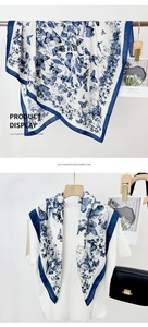 Detail of a large white shawl with navy butterfly prints and floral patterns